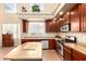 Kitchen featuring stainless steel appliances, wooden cabinets, and tile floors at 15792 W Desert Mirage Dr, Surprise, AZ 85379