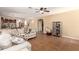 Spacious living room featuring tile flooring, ceiling fan, and open access to other rooms at 15792 W Desert Mirage Dr, Surprise, AZ 85379