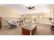 Upstairs sitting room with casual furniture, ceiling fan and large window providing natural light at 15792 W Desert Mirage Dr, Surprise, AZ 85379