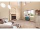 Bright living room with high ceilings, fireplace, plush seating, and large window at 15792 W Desert Mirage Dr, Surprise, AZ 85379