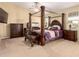 Spacious main bedroom with a four-poster bed, dresser, and carpet flooring at 15792 W Desert Mirage Dr, Surprise, AZ 85379