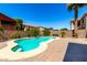 Backyard pool with a well-maintained patio, colorful flowering bushes and privacy block wall at 15792 W Desert Mirage Dr, Surprise, AZ 85379