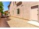 View of the home's side yard with gravel, a utility trailer, and a back door at 15792 W Desert Mirage Dr, Surprise, AZ 85379