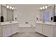 Well-lit bathroom with double vanity, soaking tub, and neutral tile flooring at 17082 S 182Nd Ave, Goodyear, AZ 85338