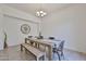 Bright dining area featuring a wooden table, bench, and modern chandelier at 17082 S 182Nd Ave, Goodyear, AZ 85338