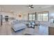Open-concept living room with a sectional sofa, glass table, and direct access to the kitchen at 17082 S 182Nd Ave, Goodyear, AZ 85338