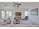 Bright living room featuring stylish furniture, a ceiling fan, a large television, and ample natural light at 17082 S 182Nd Ave, Goodyear, AZ 85338