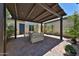 Relaxing outdoor patio featuring a shaded pergola, beautiful pavers, and comfortable seating, perfect for entertaining at 17082 S 182Nd Ave, Goodyear, AZ 85338