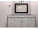 Bathroom features gray countertop and sink atop white shaker cabinets with a mirror at 1804 S Standage Cir, Mesa, AZ 85202