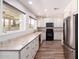 Bright kitchen features white cabinets, marble countertops, stainless steel appliances, and wood floors at 1804 S Standage Cir, Mesa, AZ 85202