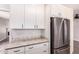 Bright kitchen features white cabinets, marble countertops, stainless steel appliances, and wood floors at 1804 S Standage Cir, Mesa, AZ 85202