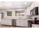 Bright kitchen features white cabinets, marble countertops, stainless steel appliances, and view to exterior at 1804 S Standage Cir, Mesa, AZ 85202