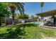 Lush backyard featuring mature palm trees, sparkling pool, covered patio, and privacy fence at 18818 N 12Th Ave, Phoenix, AZ 85027