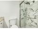 Bathroom featuring toilet, sink, and glass enclosed shower with marbled tile at 18818 N 12Th Ave, Phoenix, AZ 85027