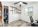 Bright bedroom with gray wood flooring, a window, ceiling fan, and closet with custom built-in shelving at 18818 N 12Th Ave, Phoenix, AZ 85027