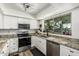 Bright kitchen featuring stainless steel appliances, granite counters, and ample natural light from the window at 18818 N 12Th Ave, Phoenix, AZ 85027