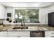 Kitchen sink under the window with granite counters, matte black faucet, and view of the exterior at 18818 N 12Th Ave, Phoenix, AZ 85027