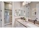 Bathroom featuring double sinks, a large mirror, and a glass-enclosed shower at 19910 W Mulberry Dr, Buckeye, AZ 85396
