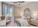 Cozy bedroom with a metal frame bed, neutral decor, and a bright window at 19910 W Mulberry Dr, Buckeye, AZ 85396