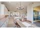 Bright dining area with modern chandelier, open to the kitchen and living space, and features sliding glass doors to the outside at 19910 W Mulberry Dr, Buckeye, AZ 85396