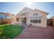 Spacious backyard featuring a covered patio, lush green lawn, and mature landscaping at 19961 N Coyote Lakes Pkwy, Surprise, AZ 85378