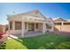 Enjoy this backyard view complete with covered patio and green space, perfect for outdoor living at 19961 N Coyote Lakes Pkwy, Surprise, AZ 85378