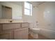 Clean bathroom featuring a single sink vanity, toilet, and tub with tiled surround at 19961 N Coyote Lakes Pkwy, Surprise, AZ 85378