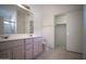 Bathroom featuring double sinks, tile flooring, and a walk-in closet at 19961 N Coyote Lakes Pkwy, Surprise, AZ 85378