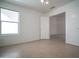 Bedroom with tiled floor, window, ceiling fan, and ensuite access at 19961 N Coyote Lakes Pkwy, Surprise, AZ 85378