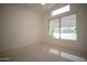 Bright bedroom with large window, neutral carpet, and sloped ceiling at 19961 N Coyote Lakes Pkwy, Surprise, AZ 85378