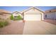 Inviting single-story home with a two-car garage, desert landscaping, and mature flowering bushes at 19961 N Coyote Lakes Pkwy, Surprise, AZ 85378