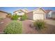 Well-maintained single-story home showcasing desert landscaping, a two-car garage, and a charming front entrance at 19961 N Coyote Lakes Pkwy, Surprise, AZ 85378