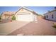 View of a two-car garage with low maintenance landscaping on a clear day at 19961 N Coyote Lakes Pkwy, Surprise, AZ 85378