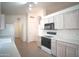 Bright kitchen with white cabinets and modern stainless steel appliances at 19961 N Coyote Lakes Pkwy, Surprise, AZ 85378