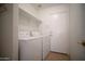 Practical laundry room with washer, dryer, shelf and easy access to the outside at 19961 N Coyote Lakes Pkwy, Surprise, AZ 85378