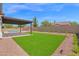 Lush backyard with artificial turf, patio area, and swimming pool at 20115 E Sonoqui E Blvd, Queen Creek, AZ 85142
