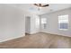 Minimalist bedroom with wood-look flooring, ceiling fan, and abundant natural light at 20115 E Sonoqui E Blvd, Queen Creek, AZ 85142