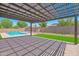 Beautiful patio with pergola overlooking a sparkling pool and well-maintained yard at 20115 E Sonoqui E Blvd, Queen Creek, AZ 85142