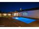 Beautiful pool with fountain features and tasteful landscaping with a covered patio illuminated at nighttime at 20115 E Sonoqui E Blvd, Queen Creek, AZ 85142