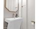 Modern powder room with pedestal sink, hexagon mirror, and gold fixtures at 20115 E Sonoqui E Blvd, Queen Creek, AZ 85142