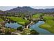 Scenic aerial view of a lush golf course community with water features and mountain views at 20437 W White Rock Rd, Buckeye, AZ 85396