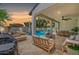 Inviting covered patio with lounge furniture overlooking a sparkling pool and manicured backyard, perfect for relaxation at 20437 W White Rock Rd, Buckeye, AZ 85396