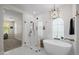 Bright bathroom featuring a standalone tub, frameless shower, and stylish light fixture at 20437 W White Rock Rd, Buckeye, AZ 85396