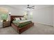 Bedroom with neutral carpet featuring a large bed, stylish side tables and lamps at 20437 W White Rock Rd, Buckeye, AZ 85396