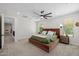 Spacious bedroom with a large bed, neutral carpet, and an elegant ceiling fan at 20437 W White Rock Rd, Buckeye, AZ 85396