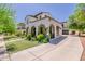 Angle view of a charming two-story home featuring stucco, arched porch, and landscaped yard at 20437 W White Rock Rd, Buckeye, AZ 85396