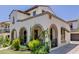 Angle view of a charming two-story home featuring stucco, arched porch, and landscaped yard at 20437 W White Rock Rd, Buckeye, AZ 85396