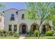 Charming front elevation highlighting the arched entryway, blooming desert landscaping, and timeless architectural details at 20437 W White Rock Rd, Buckeye, AZ 85396