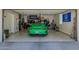This garage features epoxy floors and a green sports car with an American and Porsche flag at 20437 W White Rock Rd, Buckeye, AZ 85396