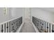 Upstairs hallway showcasing dark iron railing detail and neutral carpet at 20437 W White Rock Rd, Buckeye, AZ 85396